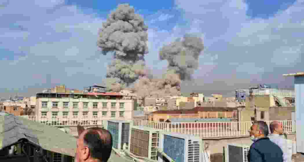 People watch as smoke rises on the skyline after an explosion in Tehran, Iran on February 28, 2026. (Photo credit: AP)