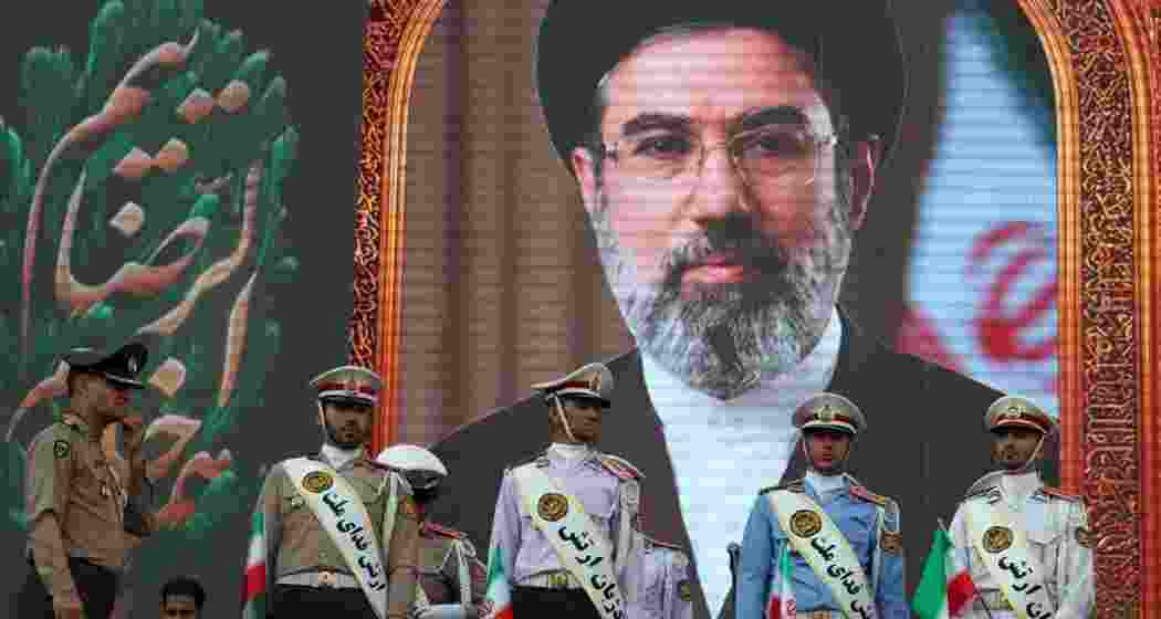 Iranian army soldiers stand in front of a picture of Iran's supreme leader Ayatollah Mojtaba Khamenei during a rally in Tehran on Wednesday. (Image credit: AFP-JIJI)