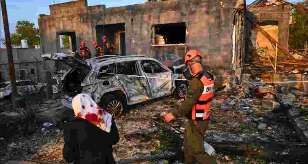 Residents and officers from Israel's Home Front Command inspect a house destroyed by an Iranian missile strike in Zarzir, northern Israel on Friday.