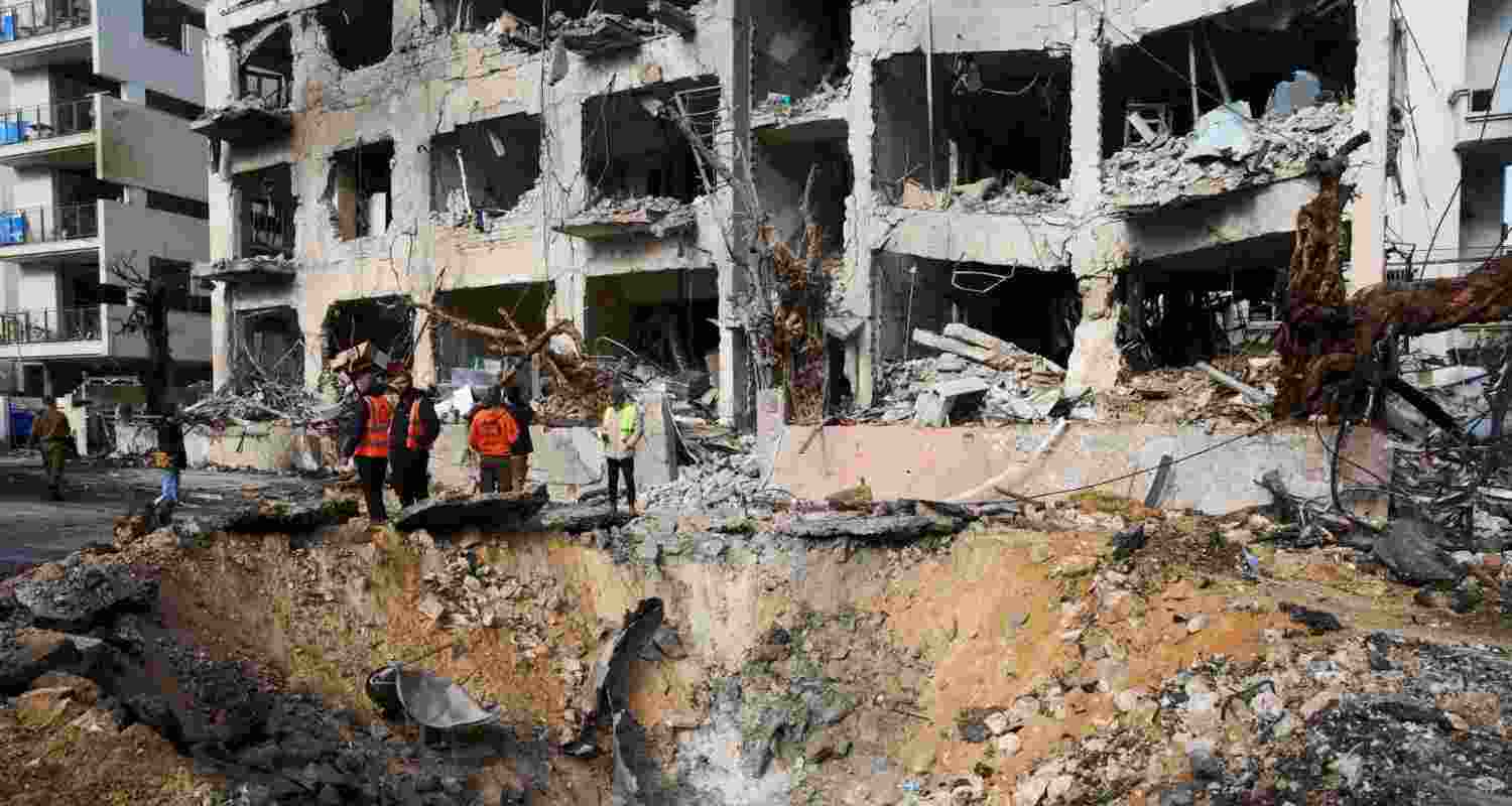 Rescue workers and military personnel survey the scene of a direct hit a day after an Iranian missile struck in Tel Aviv, Israel, Sunday. 


