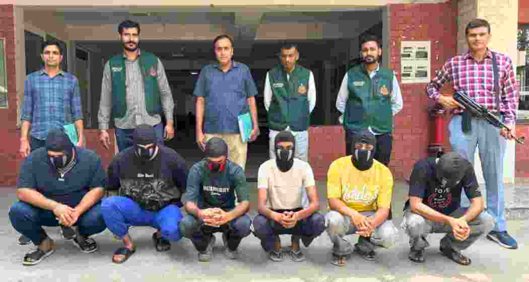 Delhi Police officials pose for a photograph with the accused persons in custody after they were arrested for their alleged involvement in an ISI-linked espionage network, in New Delhi on Friday.