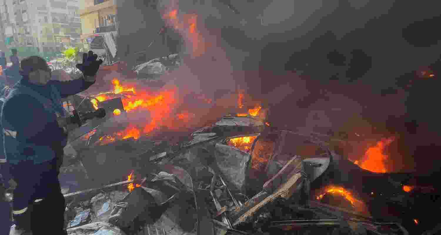 A rescue worker extinguishes burning cars at the site of an Israeli airstrike in central Beirut, Lebanon, Wednesday. 