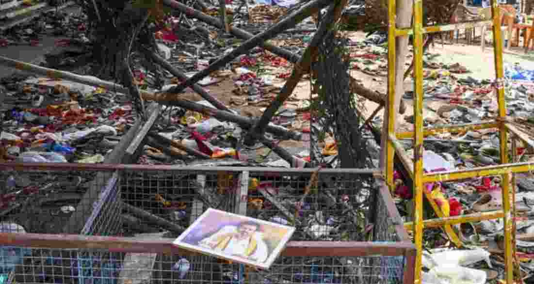 A portrait of Vijay lies on a metal fencing after the stampede. 