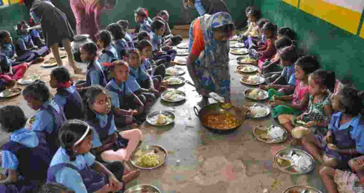 Students being served mid-day meal in a school.