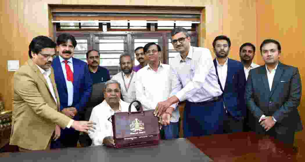 Karnataka Chief Minister Siddaramaiah, flanked by officials, holds the state budget briefcase ahead of presenting the Karnataka Budget 2025-26, which focuses on welfare schemes, agriculture, and industrial growth.