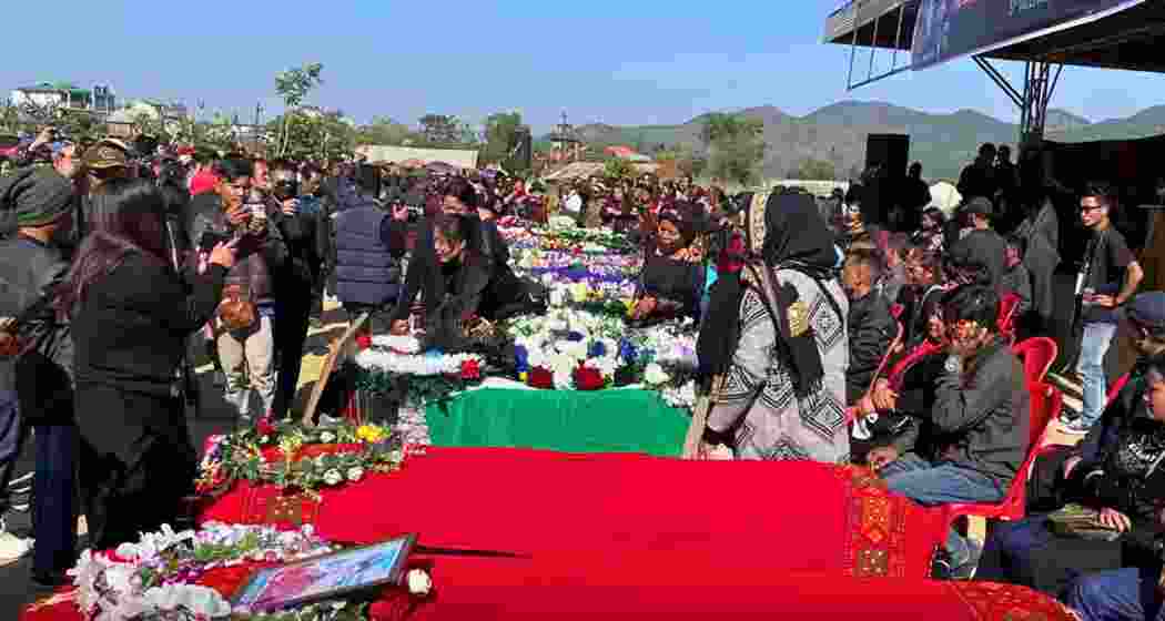 Mourners gather at Peace Ground in Tuibuong, Churachandpur, as the coffins of 12 Kuki-Zo youths, draped in traditional shawls, are laid to rest during a solemn funeral ceremony.