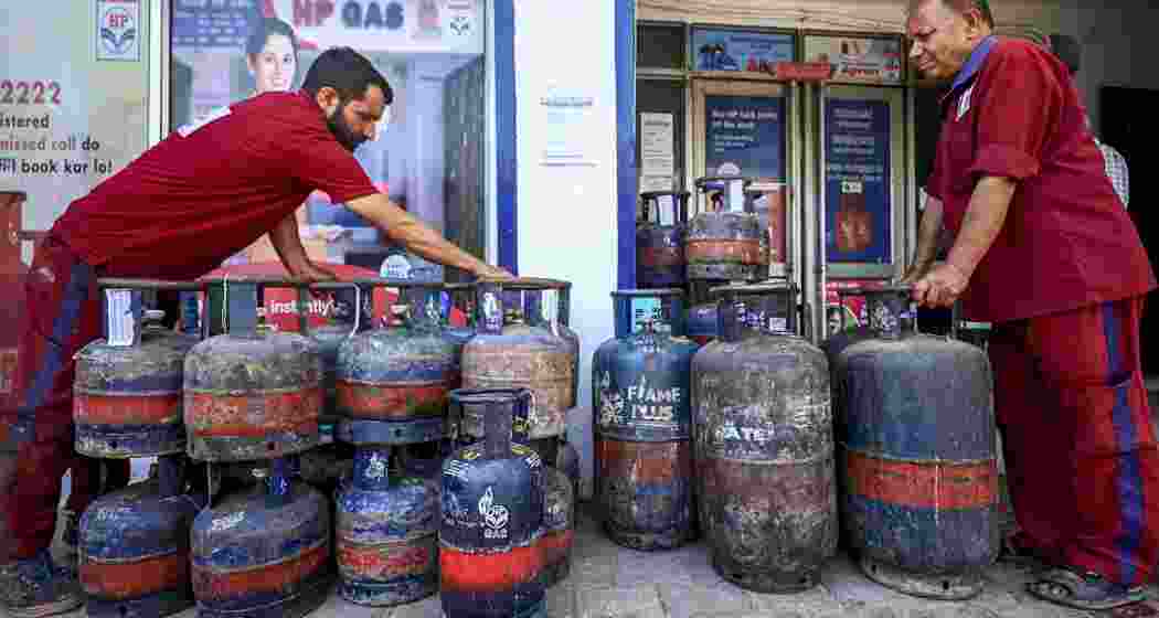 Workers stack LPG cylinders at a gas agency, in Jammu, Jammu and Kashmir, on Friday.