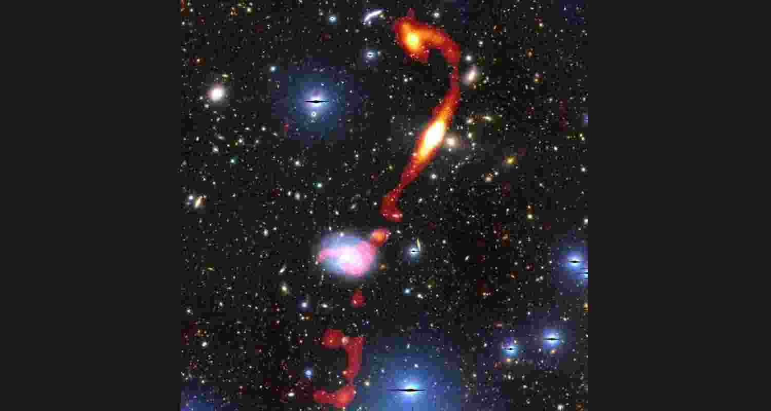Inkathazo’s glowing plasma jets are shown in red and yellow. The starlight from other surrounding galaxies can be seen in the background.