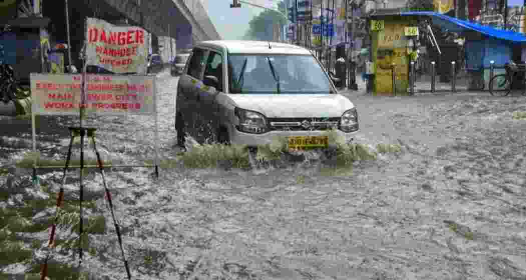 A vehicle wades through a waterlogged road amid rainfall, in Hindamata area, in Mumbai, in Tuesday.