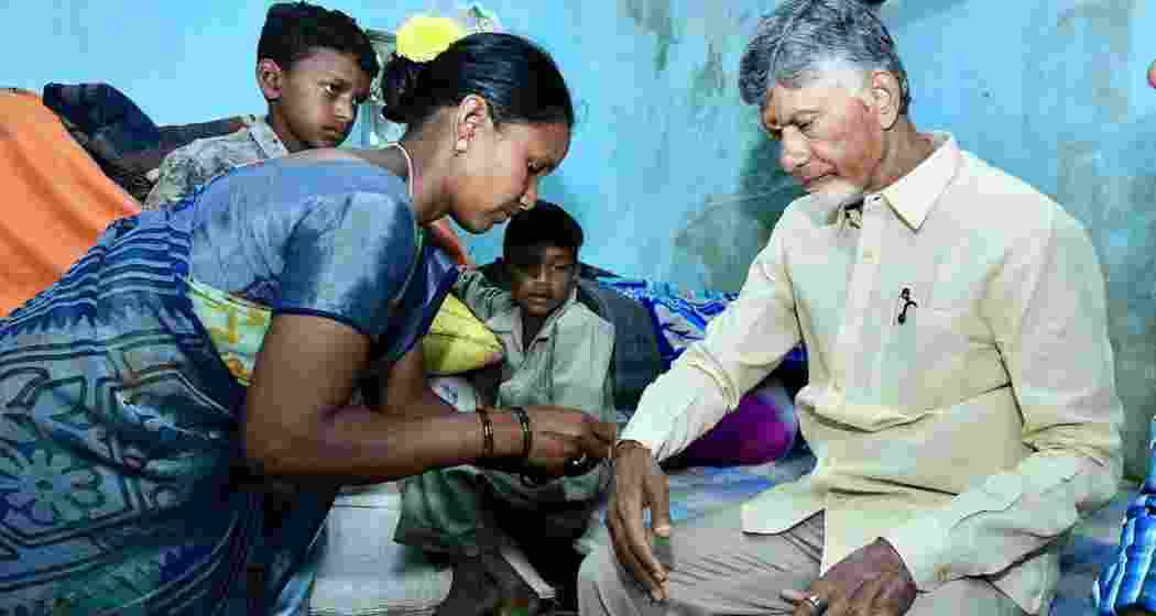 Chandrababu Naidu ties a rakhi presented by a tribal woman during World Tribal Day celebrations on Saturday. 