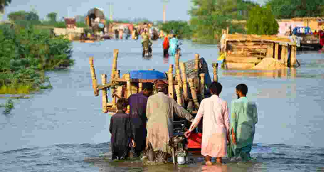 Residents wade through waist-deep floodwaters, pushing a cart along a submerged road in Pakistan’s Punjab province as monsoon rains continue to wreak havoc across the region.