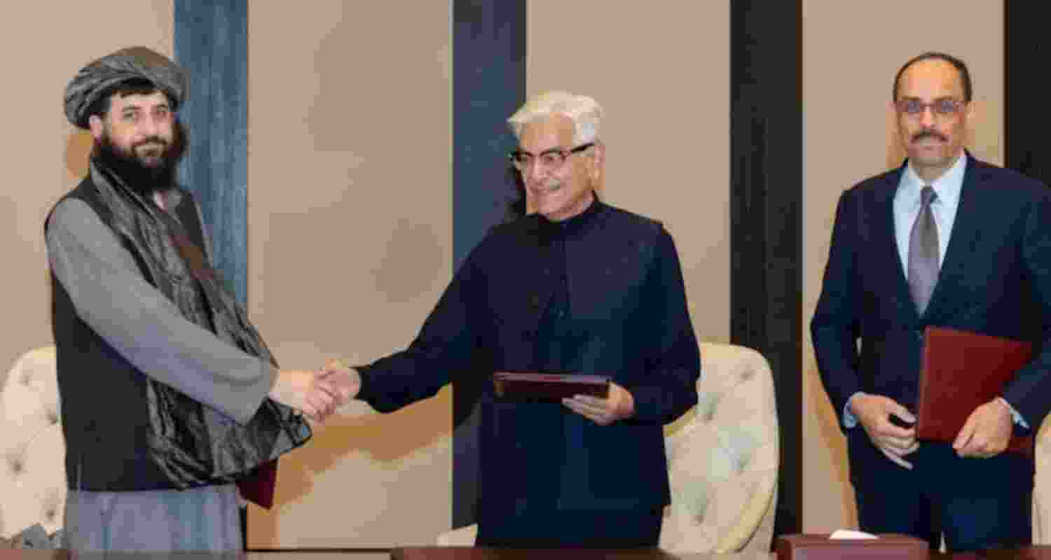 Afghanistan’s Defence Minister Mullah Muhammad Yaqoob shakes hands with Pakistani counterpart Khawaja Muhammad Asif during peace talks in Doha. 