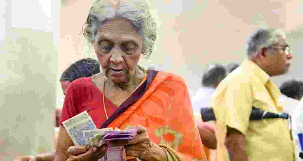 An old-aged lady carefully counts her pension money.