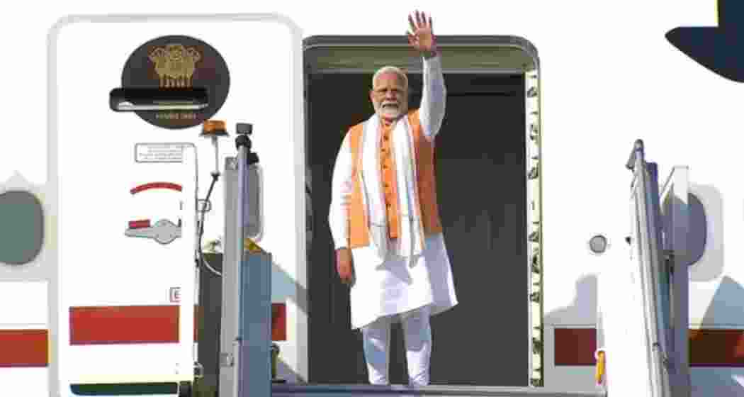 PM Modi waves before boarding his flight from New Delhi on Wednesday, beginning a five-nation diplomatic tour with stops in Africa, South America, and the Caribbean. The tour marks his longest diplomatic visit in nearly a decade. 