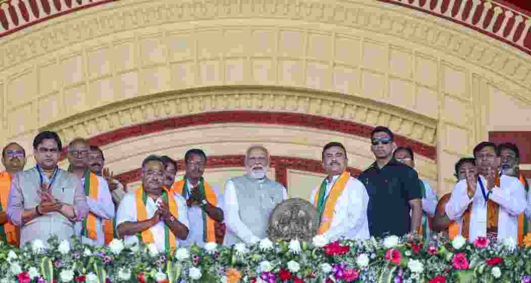 Prime Minister Narendra Modi being garlanded by West Bengal BJP President Samik Bhattacharya, LoP in the state Assembly Suvendu Adhikari during a rally, at Brigade Parade Ground in Kolkata, on Saturday.