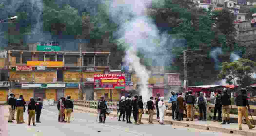 Police personnel stand on a bridge as they stop the protesters of the Awami Action Committee during a protest following a shutter-down strike in Muzaffarabad, the capital of Pakistan Occupied Jammu and Kashmir (PoJK).