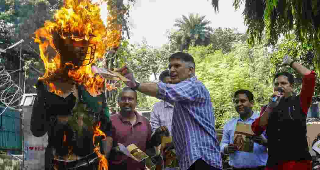 AAP leader Saurabh Bharadwaj burns an effigy during a protest against the upcoming Asia Cup cricket match between India and Pakistan, at the party office in New Delhi, Saturday.