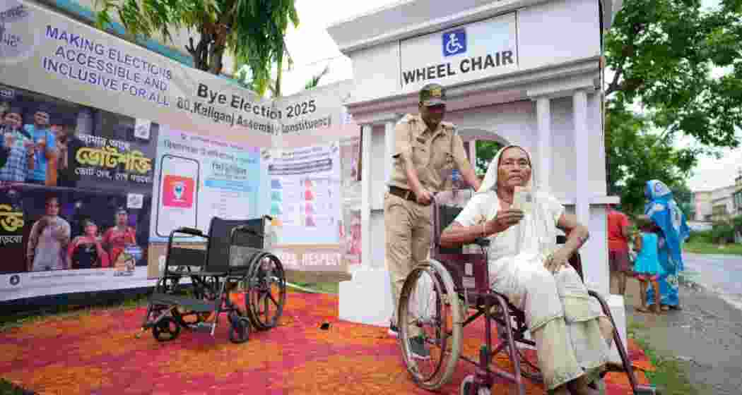 An elderly voter being assisted by security personnel on her arrival at a polling booth in Kaliaganj, West Bengal.