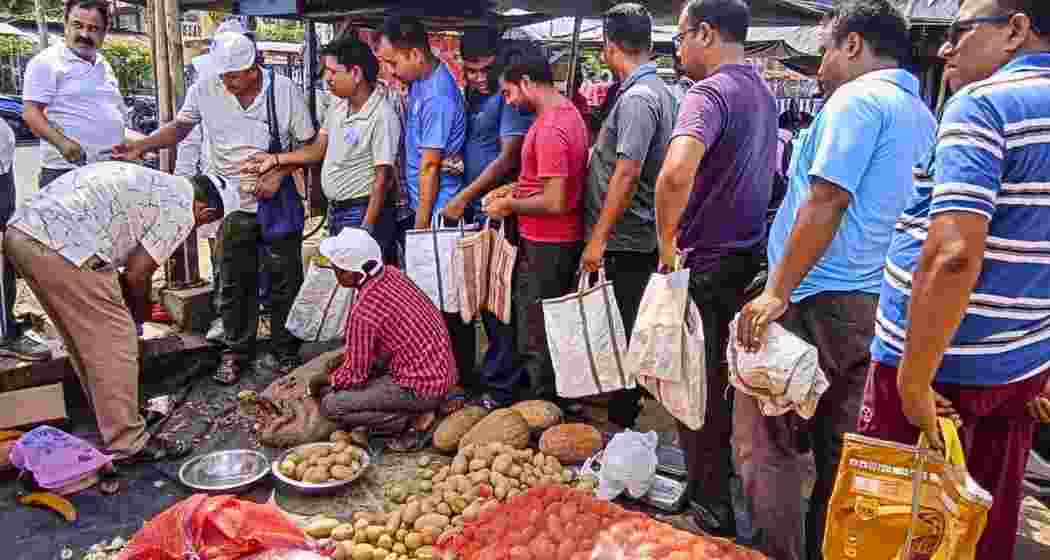 People queue up to purchase potatoes at subsidised rates from a West Bengal Government’s Food Department outlet, in Balurghat.