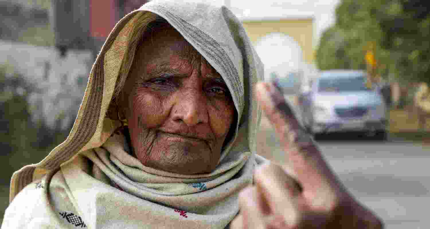 An elderly woman shows her ink marked finger after casting vote at a polling station during 'Zila Parishad' and 'Panchayat Samiti' elections, on the outskirts of Amritsar, Punjab, Sunday. 