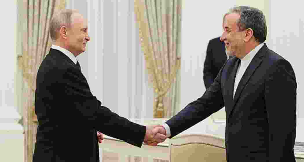 Russia's President Vladimir Putin shakes hands with Iran's Foreign Minister Abbas Araghchi during a meeting at the Kremlin in Moscow on April 17, 2025. 
