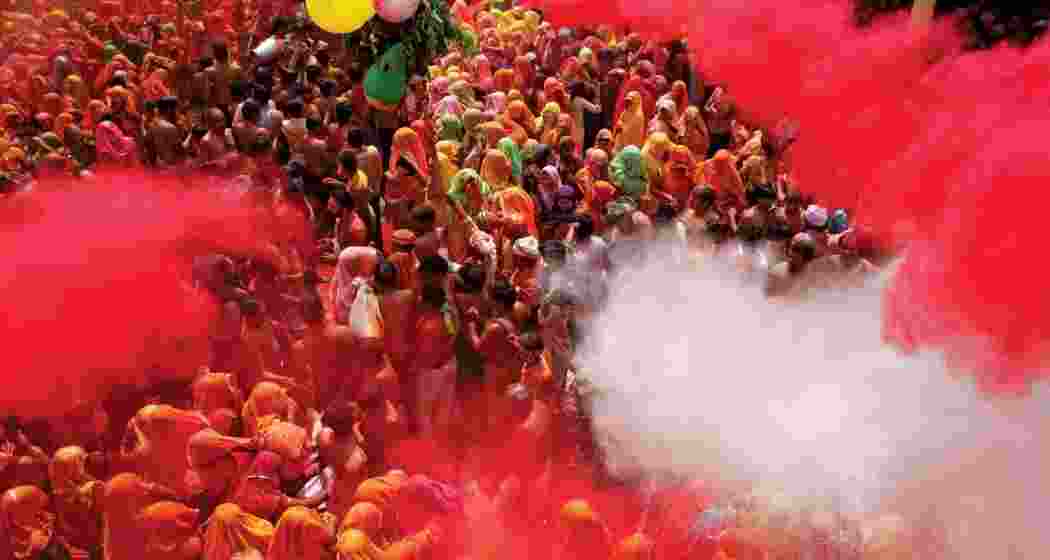 People celebrate the festival of Holi with colours and flower petals at the Shri Bankey Bihari Temple in Vrindavan on the occasion of Rangbhari Ekadashi.