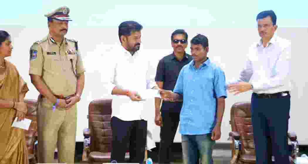 Telangana Chief Minister A. Revanth Reddy with one of the 130 maoists who surrendered on Saturday.