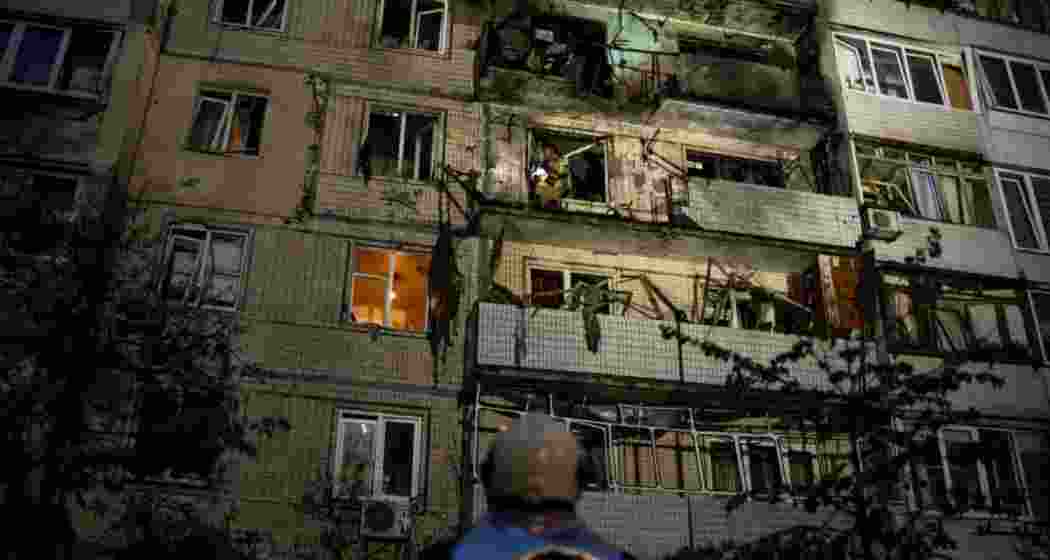 An emergency worker directs colleagues at the scene of a residential building damaged during a Russian strike in Kyiv, Ukraine, on Saturday, 24 May 2025.