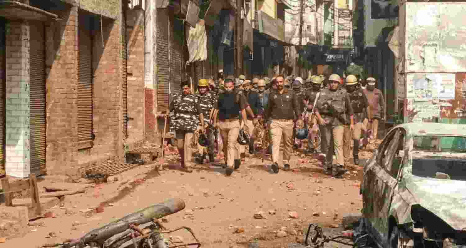 Police march during riots in Sambhal.