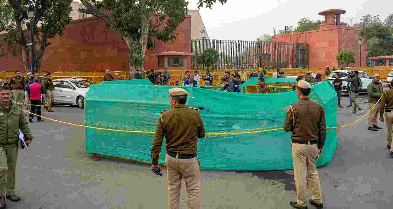 Delhi Police personnel during investigation at the site where a man tried to immolate himself near the Railway Bhawan opposite the new Parliament building, in New Delhi, Wednesday, Dec. 25, 2024. 