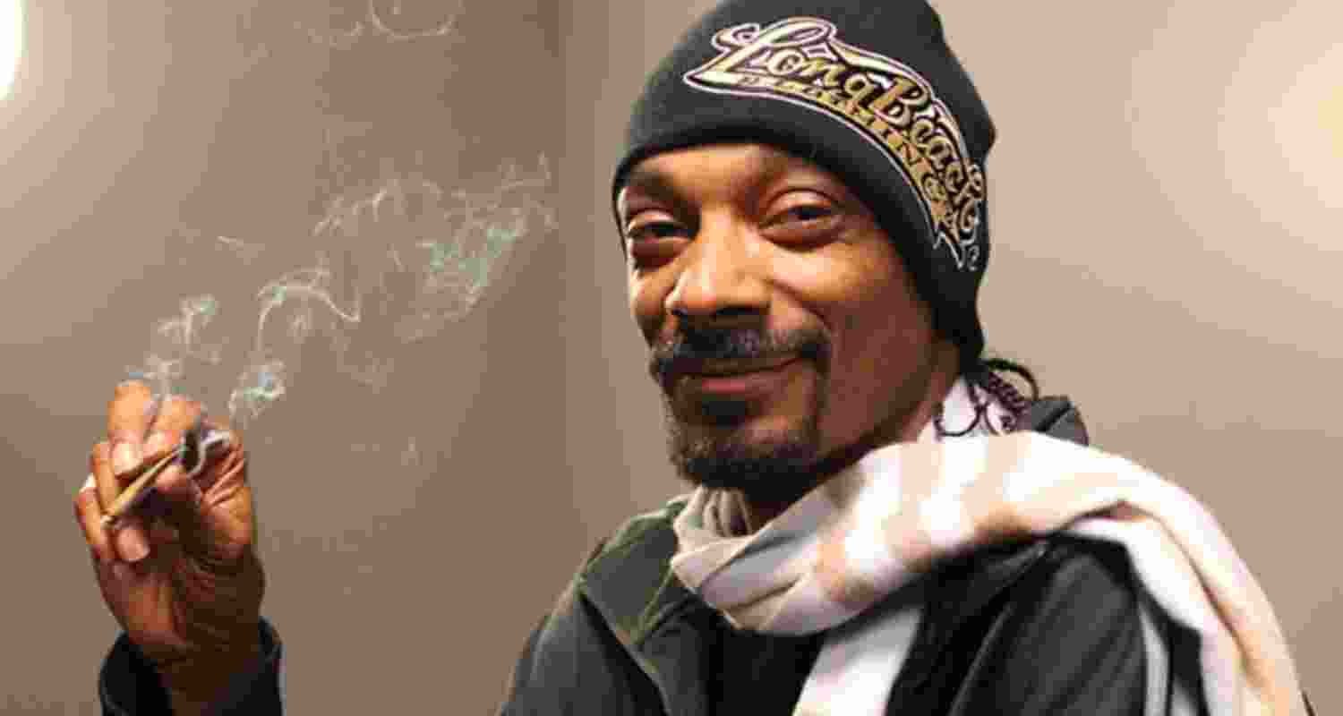 US rapper and musician Snoop Dogg, while smoking marijuana. The artist has quite literally made a name for himself in the rap industry for his cannabis use.