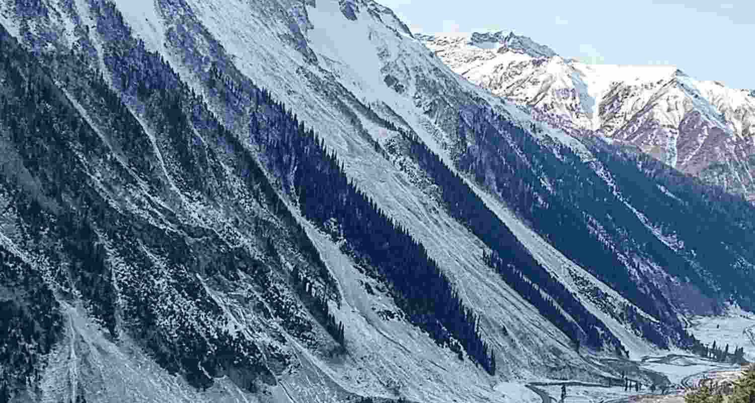 People walk along the Amarnath track as fresh snowfall blankets the area, in Baltal, Jammu and Kashmir, Sunday. 