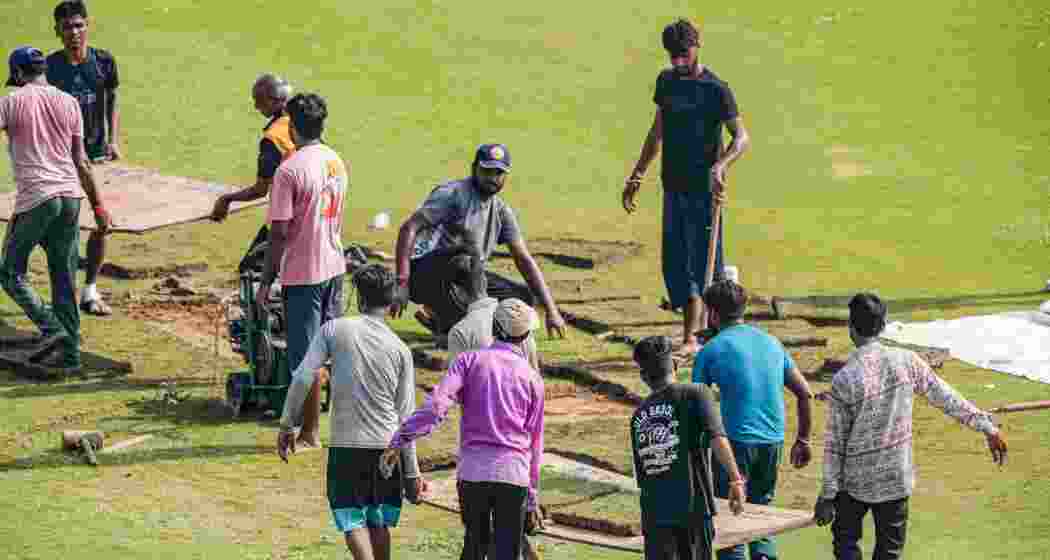 Ground staffers put grass patches on the ground before the start of the second day of one-off Test match between Afghanistan and New Zealand, in Greater Noida, Tuesday, Sept 10, 2024. The first day of the test was washed out.