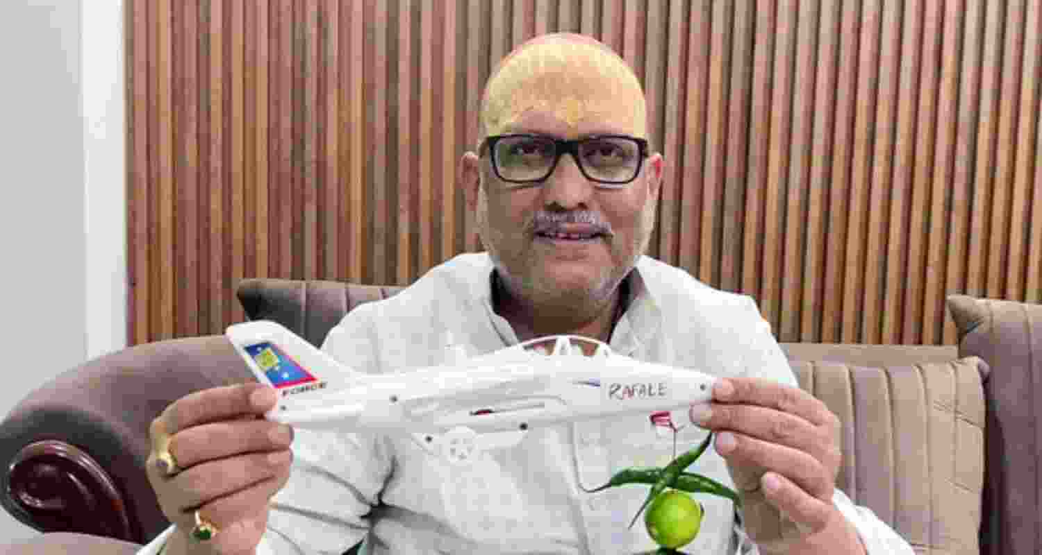 Uttar Pradesh Congress President Ajay Rai while speaking to media shows a 'toy plane' with Rafale written on it and lemon-chillies hanging in it, in Varanasi on Sunday.