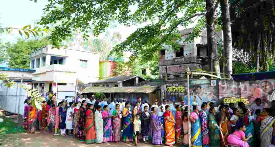 People stand in a queue waiting for their turn to vote at a polling station in West Bengal's Bankura district.