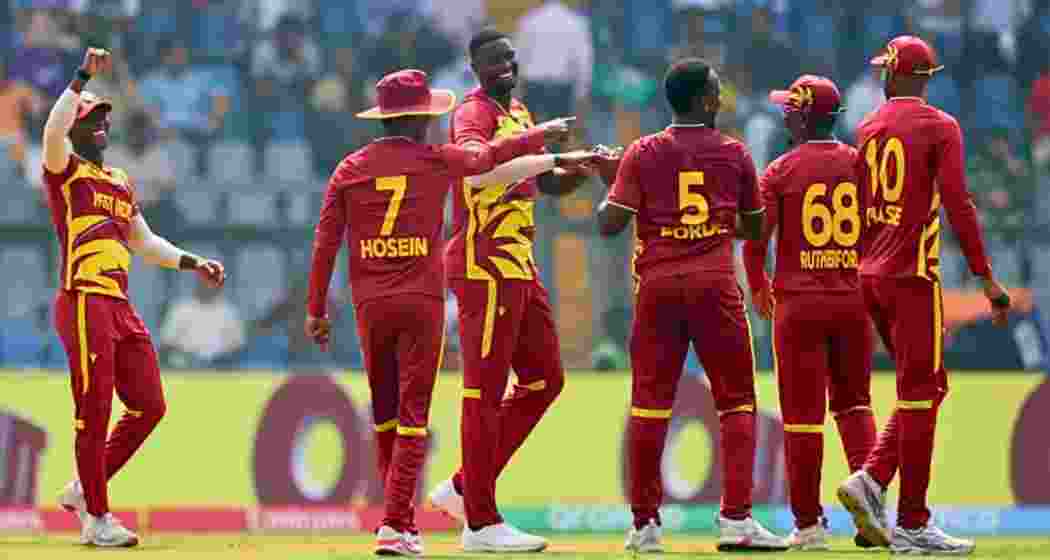 West Indies players celebrate a wicket during a T20 World Cup match.
