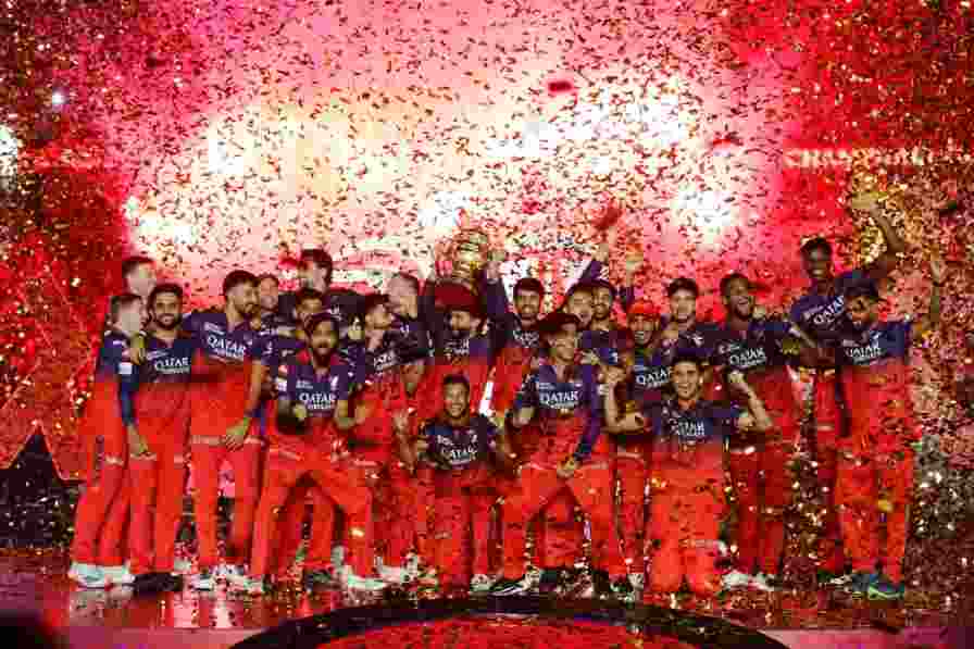 RCB players celebrating after receiving the IPL trophy in Bengaluru.