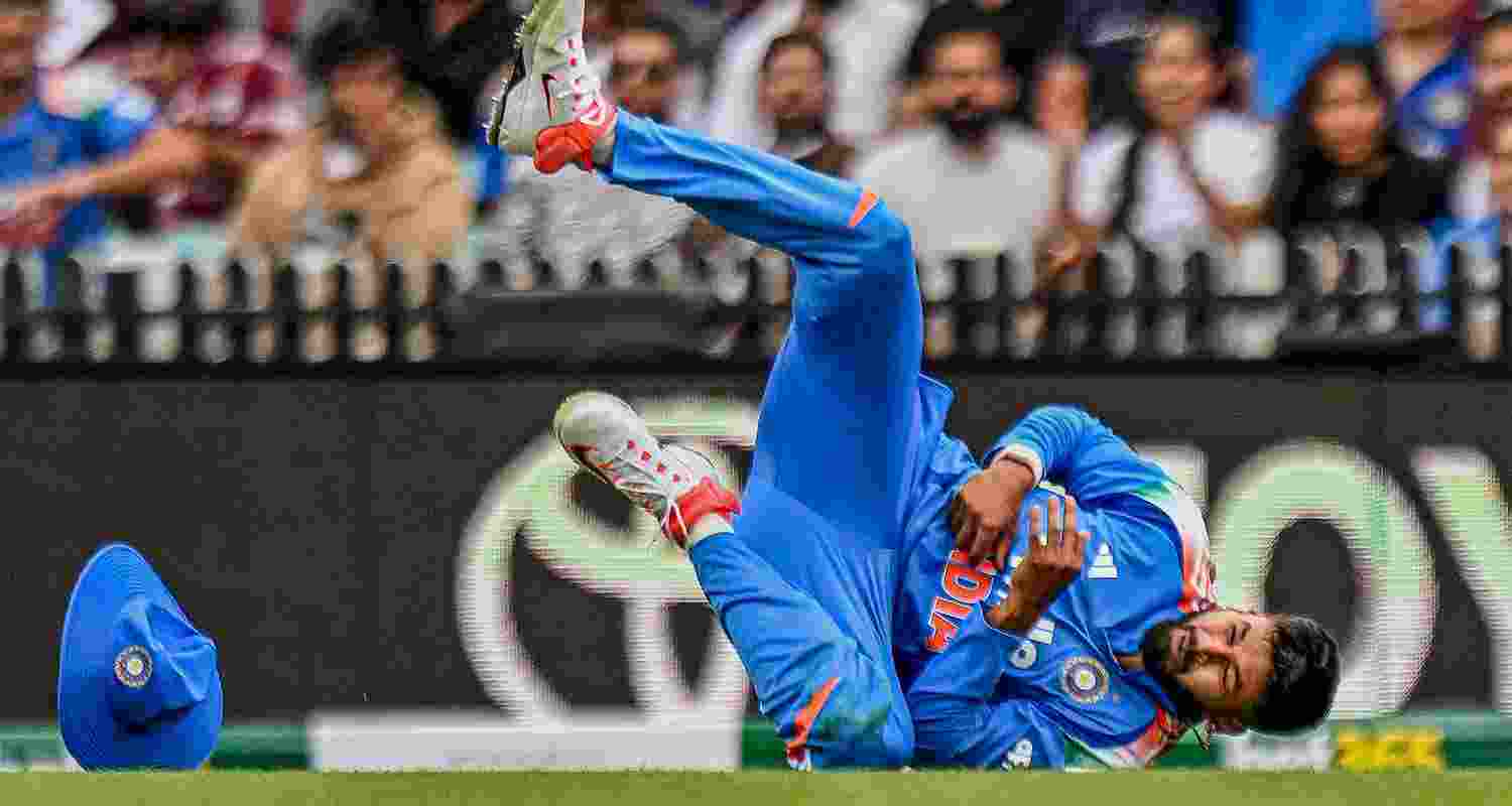 Shreyas Iyer reacts after sustaining an injury while taking the catch of Australia's Alex Carey during the third ODI cricket match between India and Australia in Sydney on Saturday.