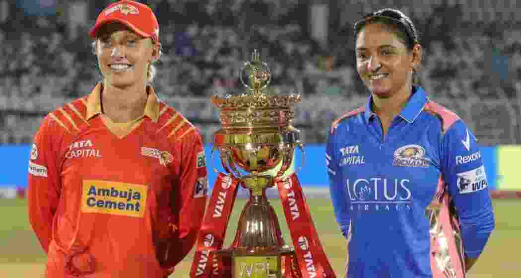 Ashleigh Gardner of Gujarat Giants and Harmanpreet Kaur of Mumbai Indians share a moment with the WPL trophy. 