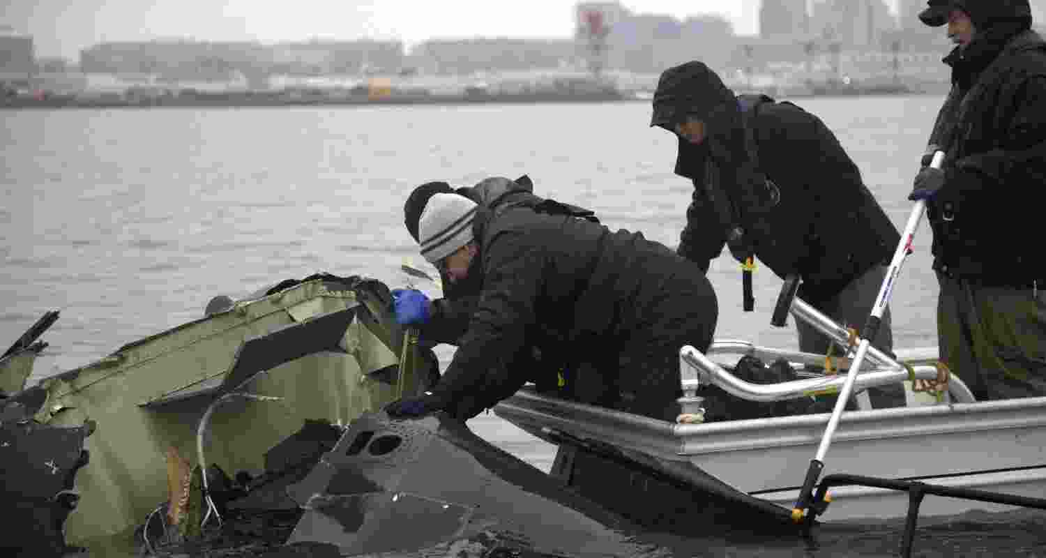 In this undated image provided by the National Transportation Safety Board, NTSB investigators and members of the salvage crew recover wreckage from the Army Black Hawk helicopter that collided with an American Airlines jet Wednesday night, Jan. 29.