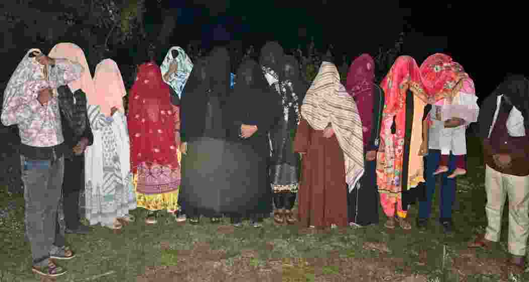 Migrants await verification before being deported at a designated border gate in Assam during a late-night push-back operation conducted by security agencies. Migrants await verification before being deported at a designated border gate in Assam during a late-night push-back operation conducted by security agencies.