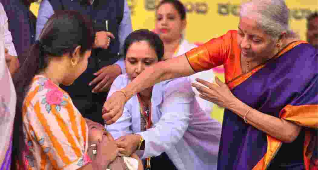 Union Finance Minister Nirmala Sitharaman administers oral polio drops to a child during the statewide pulse polio immunisation drive at Kamalapura in Karnataka on Sunday. Union Finance Minister Nirmala Sitharaman administers oral polio drops to a child during the statewide pulse polio immunisation drive at Kamalapura in Karnataka on Sunday.