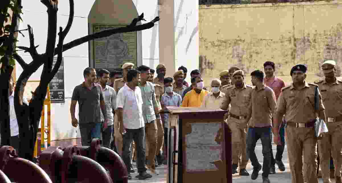Police escort eight accused in the alleged Ram Mandir donation embezzlement case after they were produced before a court in Ayodhya, which remanded them to judicial custody till June 29. Police escort eight accused in the alleged Ram Mandir donation embezzlement case after they were produced before a court in Ayodhya, which remanded them to judicial custody till June 29.