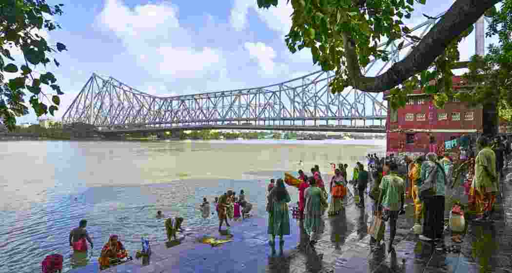 People gather along a Ganga ghat in Kolkata, West Bengal, with the Howrah Bridge visible in the background. People gather along a Ganga ghat in Kolkata, West Bengal, with the Howrah Bridge visible in the background.