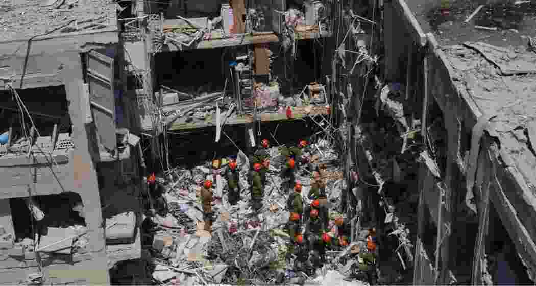 Israeli soldiers dig through rubble to search for survivors in a residential area hit by a missile fired from Iran, in Bat Yam, central Israel, Sunday. Israeli soldiers dig through rubble to search for survivors in a residential area hit by a missile fired from Iran, in Bat Yam, central Israel, Sunday.
