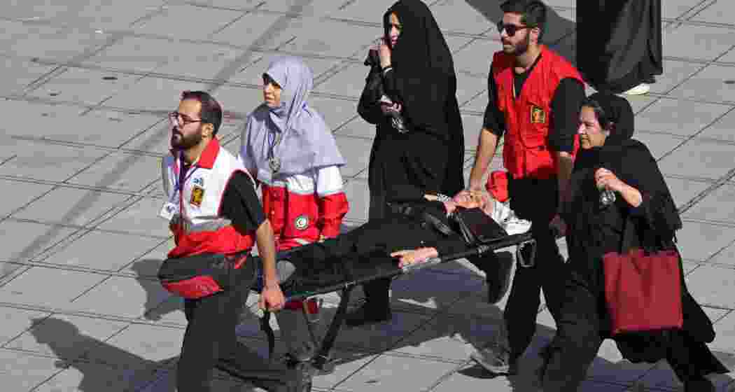 Red Crescent personnel carry an elderly woman on a stretcher who had fainted in the crowd at the Grand Mosalla during the funeral ceremonies for Iran's slain supreme leader Ayatollah Ali Khamenei, in Tehran on July 4, 2026. Funeral ceremonies for Iran's supreme leader Ali Khamenei officially began on July 4, state television reported, an event drawing thousands and intended to serve as a show of strength to the Islamic republic's foes.(AFP) Red Crescent personnel carry an elderly woman on a stretcher who had fainted in the crowd at the Grand Mosalla during the funeral ceremonies for Iran's slain supreme leader Ayatollah Ali Khamenei, in Tehran on July 4, 2026. Funeral ceremonies for Iran's supreme leader Ali Khamenei officially began on July 4, state television reported, an event drawing thousands and intended to serve as a show of strength to the Islamic republic's foes.(AFP)