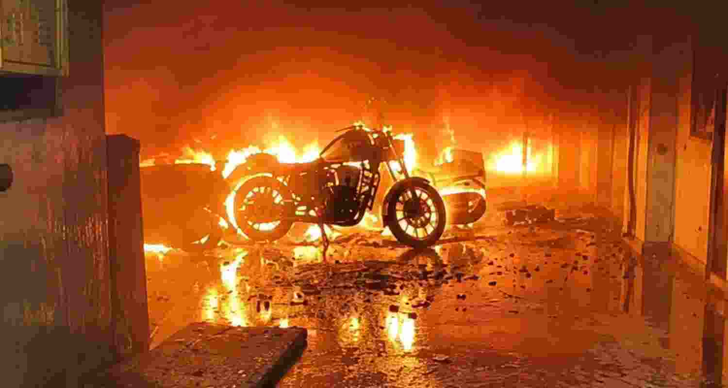 Two people died after an EV being charged caught fire in a Noida building, triggering a blaze that spread to parked vehicles. Nearly 50 residents were rescued. Two people died after an EV being charged caught fire in a Noida building, triggering a blaze that spread to parked vehicles. Nearly 50 residents were rescued.