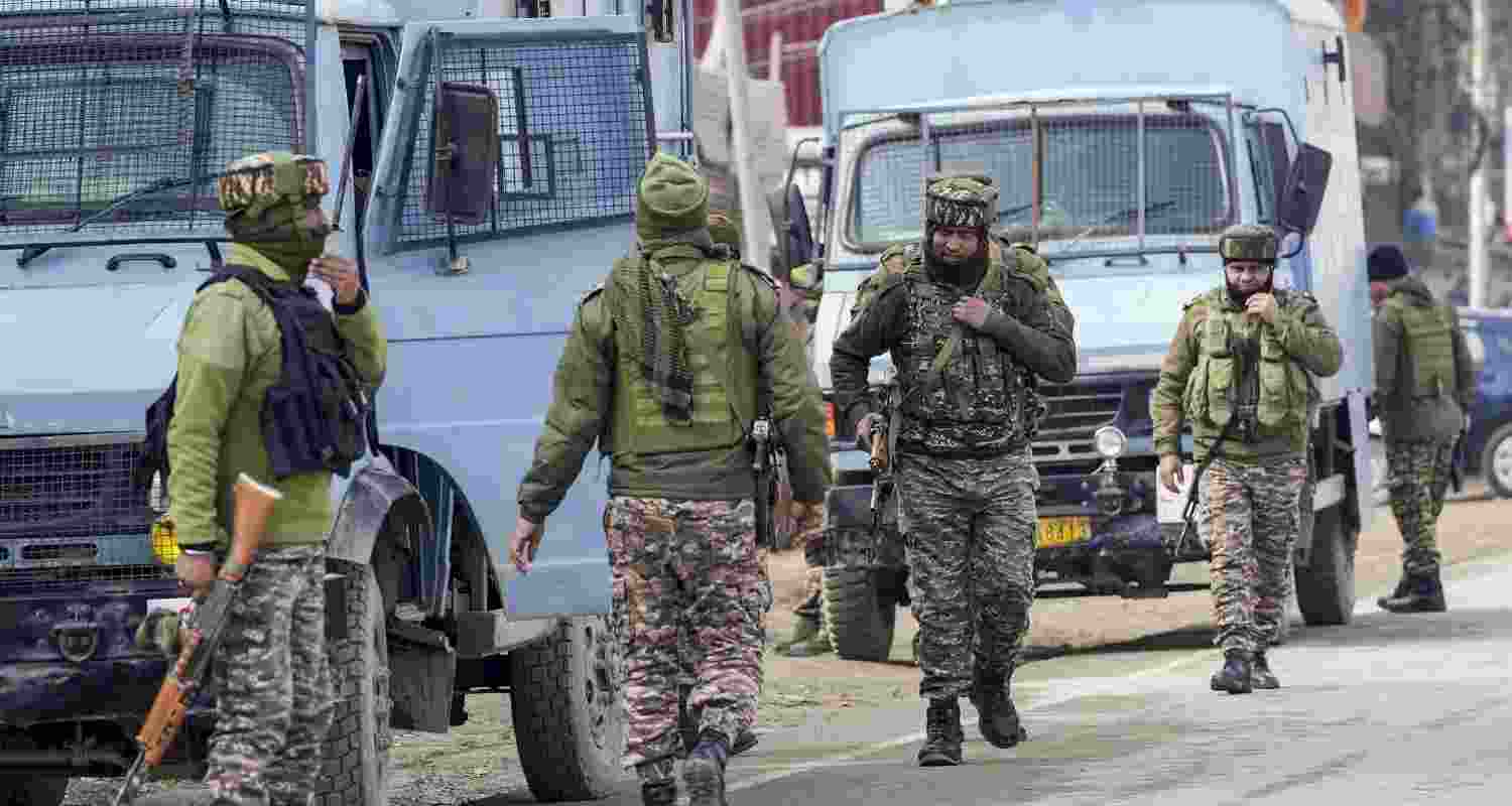 Security personnel keep vigil as National Investigation Agency (NIA) conducts raid, on the outskirts of Srinagar, Monday. Security personnel keep vigil as National Investigation Agency (NIA) conducts raid, on the outskirts of Srinagar, Monday.