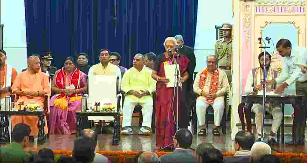 Uttar Pradesh Chief Minister Yogi Adityanath (L) looks on as Governor Anandiben Patel administers the oath at Raj Bhavan during the swearing-in ceremony of six BJP leaders inducted into the council of ministers. Uttar Pradesh Chief Minister Yogi Adityanath (L) looks on as Governor Anandiben Patel administers the oath at Raj Bhavan during the swearing-in ceremony of six BJP leaders inducted into the council of ministers.